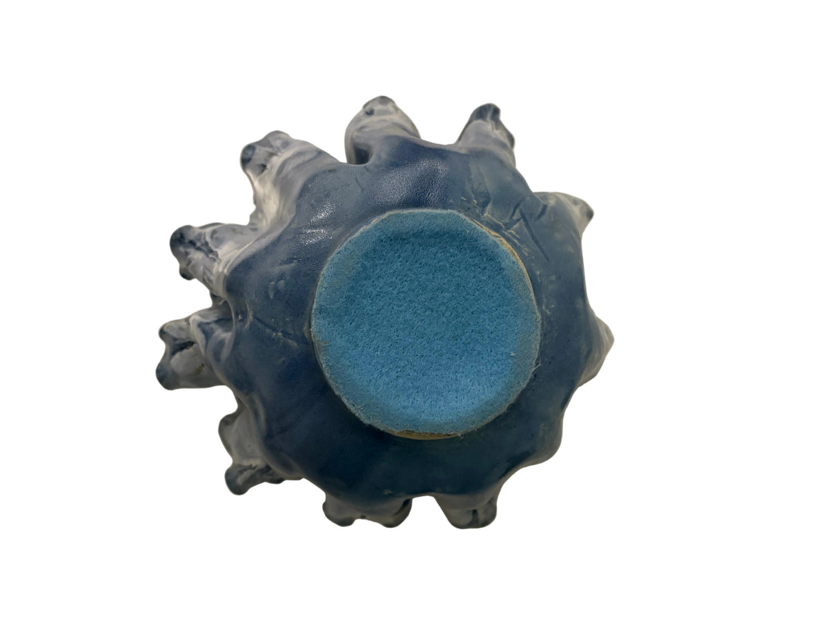 Top view into deep blue decorative bowl with folded wavy rim