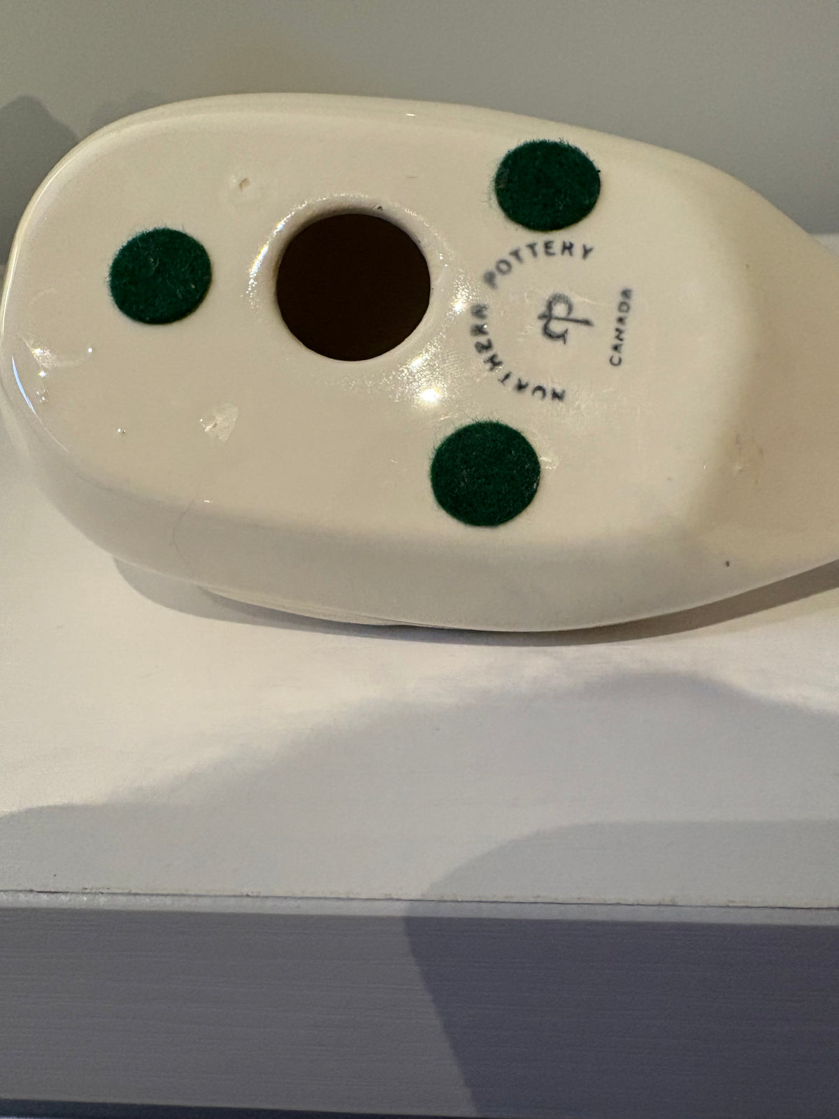 Underside of white duck figurine with Nuance Pottery Canada mark